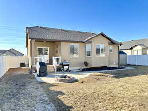 Rear view of property with a fire pit and a patio