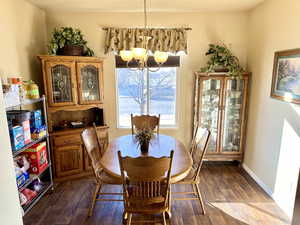 Dining area featuring dark wood-type flooring and an inviting chandelier