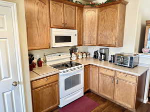 Kitchen featuring white appliances and dark hardwood / wood-style floors