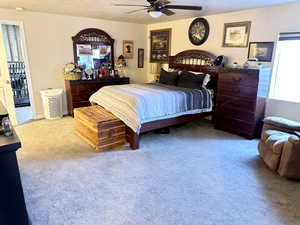 Carpeted bedroom featuring ceiling fan