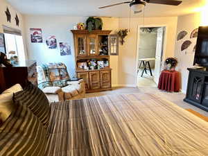 Living room with ceiling fan and light carpet