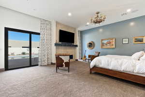 Carpeted bedroom featuring access to outside and a chandelier