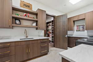 Kitchen featuring light stone countertops, sink, and stove