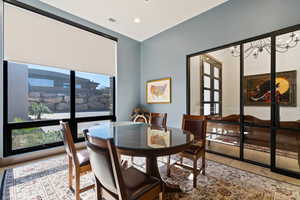 Dining room featuring hardwood / wood-style floors, a wealth of natural light, an inviting chandelier, and french doors