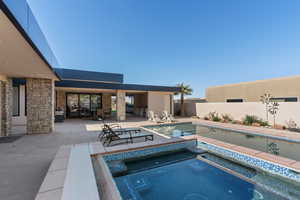 View of swimming pool with an in ground hot tub and a patio area