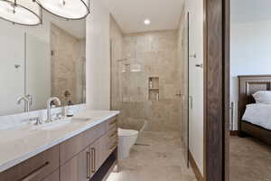 Bathroom with vanity, a shower with shower door, and toilet