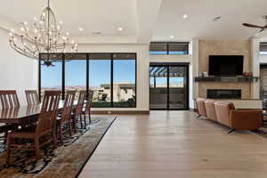 Dining room featuring ceiling fan, a tiled fireplace, and hardwood / wood-style floors