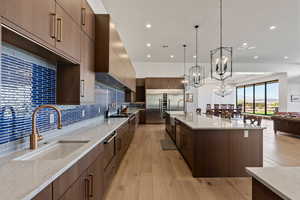 Kitchen with pendant lighting, sink, a chandelier, and light wood-type flooring