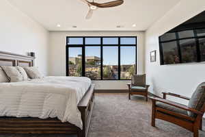 Carpeted bedroom featuring ceiling fan