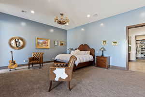 Bedroom with an inviting chandelier and carpet