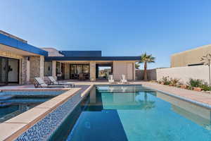 View of pool with an in ground hot tub and a patio