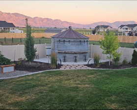 Yard at dusk with a patio, a swimming pool, and a mountain view