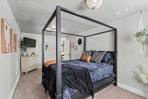 Bedroom with carpet and a textured ceiling