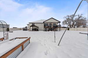 Snow covered back of property with a gazebo and a trampoline