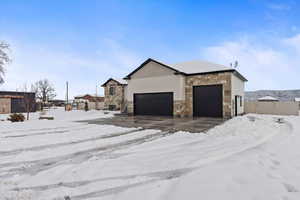 Snow covered property with a garage