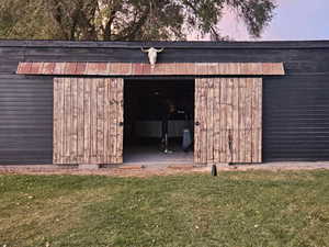 Outdoor structure at dusk featuring a yard