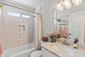 Full bathroom with vanity, toilet, and shower / bath combo with shower curtain