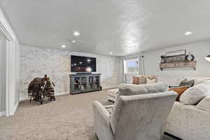 Carpeted living room with a textured ceiling
