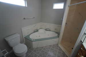 Full bathroom featuring plus walk in shower, toilet, tile patterned flooring, and a wealth of natural light