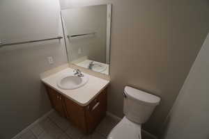 Bathroom featuring vanity, tile patterned floors, and toilet