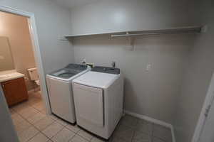 Laundry room featuring light tile patterned flooring and independent washer and dryer