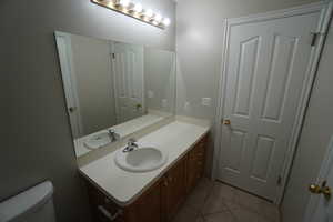 Bathroom featuring vanity, tile patterned flooring, and toilet