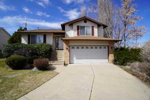 Tri-level home with a garage and a front yard