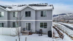 Snow covered back of property featuring a mountain view