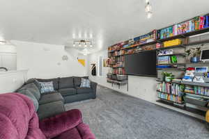 Living room with rail lighting and carpet floors