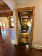 Both staircases featuring wood finished floors, wood ceiling with exposed beams, and baseboards
