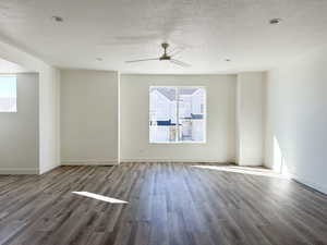 Empty room featuring ceiling fan, wood-type flooring, and a textured ceiling