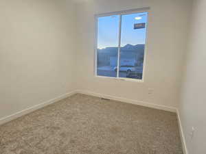 Empty room featuring carpet flooring and a mountain view