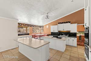 Kitchen featuring white cabinetry, sink, and a kitchen island