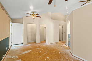 Unfurnished bedroom featuring ceiling fan and lofted ceiling