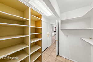 Walk in closet with light tile patterned floors