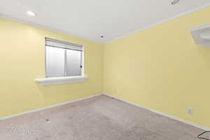 Carpeted empty room featuring crown molding