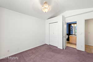 Unfurnished bedroom featuring ensuite bathroom, carpet flooring, a textured ceiling, and a closet