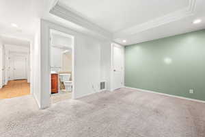 Carpeted spare room featuring a tray ceiling