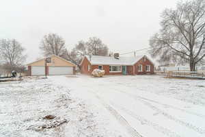 View of front of property with a garage, an outdoor structure, and a trampoline