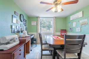 Tiled dining room with ceiling fan and a textured ceiling