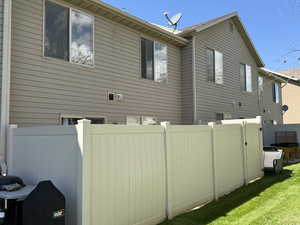 View of side of property featuring fence and a yard