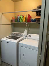 Laundry area with washer and dryer and light tile patterned floors