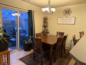 Dining area with a chandelier and light tile patterned floors