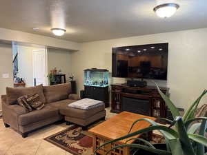 Living room with a textured ceiling and light tile patterned floors