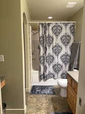 Full bathroom with vanity, toilet, and shower / bath combo with shower curtain