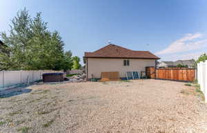 Rear view of house featuring a hot tub