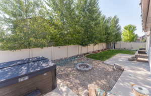 View of yard featuring a patio area, a hot tub, and an outdoor fire pit