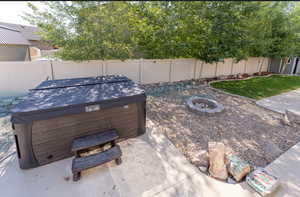 View of yard featuring a hot tub and a fire pit