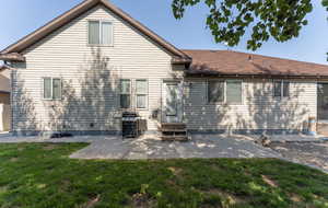 Back of property with a patio and a lawn