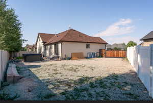 Rear view of house with a hot tub and a patio